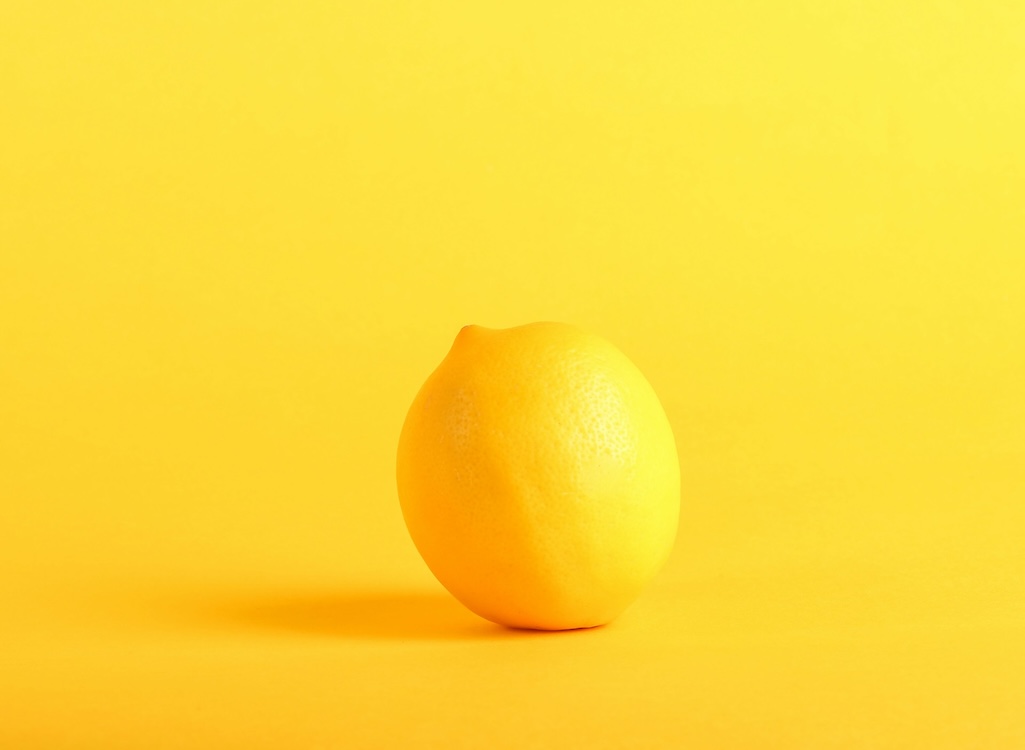A lemon on a yellow background, symbolising the lemons of UX design - Unsplash